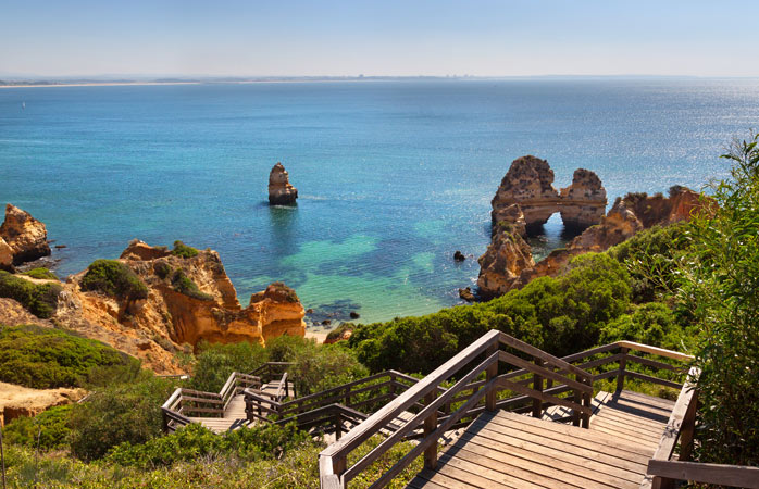 Explore golden sandstone cliffs, natural tunnels and hidden grottos at Ponda da Piedade beach