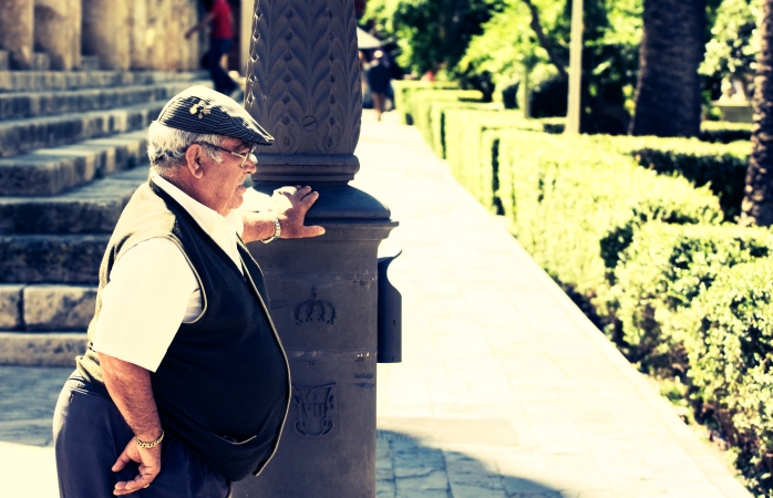 An old Sevilliano rests by a lamp-post on a hot summer's day.