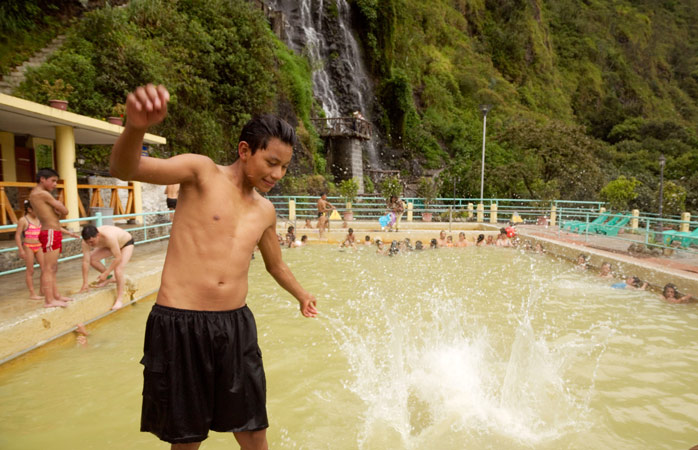 Mingle with locals at the thermal baths in Baños, complete with a view of the waterfall